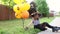 Teen girl posing with bunch of orange halloween balloons sitting on the street.