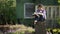 Teen girl reads book sitting on a stump in the yard