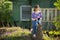 Teen girl reads book sitting on a stump in the yard in the village. Education.