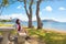 Teen girl relaxing on shaded bench by Hawaiian ocean