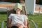 Teen girl resting outdoor sitting in chair, reading book and sleeping