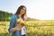 Teen girl with ripe sunflower plant. Autumn natural landscape