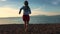 Teen girl running on the beach at the daytime. Young girl walking on the sea.