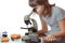 Teen girl in school laboratory. Researcher working with microscope