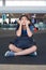 Teen girl sitting on airport floor with luggage, resting