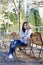 Teen girl sitting on bench under cherry tree