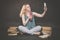 Teen girl sitting on the floor next to books, does not want to learn, drinking juice and taking a selfie on the smartphone