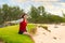 Teen girl sitting on grassy beach by ocean in Hawaii