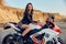 Teen girl sitting on a racing motorcycle, beautiful biker in a short skirt on a sports motorcycle in nature. A friend of