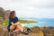 Teen girl sitting on rocks overlooking Makapu`u beach, Oahu, Hawaii