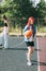 Teen girl with a skateboard on a sports field, blurred foreground