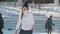 Teen girl skillfully skating on outdoor public ice rink, slow-motion