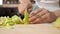 Teen girl is slowly cutting apple on small pieces, hands closeup.