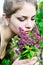 Teen girl smelling lilac blossoms