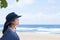 Teen girl smiling, looking out over ocean, side profile