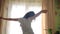 Teen girl stretches awake standing at window