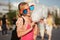 Teen girl in sunglasses eating cotton candy on city street