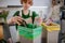 Teen girl throwing glass bottles in recycling bin in the kitchen.