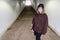 Teen Girl walking through a tunnel with her skateboard