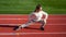 teen girl warming up on stadium. kid in sportswear stretching. child do exercise on racing track. healthy childhood