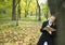 Teen girl writes a poetry in autumn park