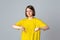 Teen girl in yellow casual tshirt looking displeased showing rejection and negative with thumbs down gesture, stand over light