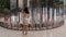 Teen in grey dress standing in front of multiple mirrors