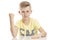 Teen guy shows a fist while sitting at the table. Isolated over white background