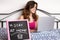 Teen in her bedroom using a laptop during a quarantine with a Stay At Home sign - Focused on the sign