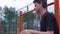 Teen listens to music on the basketball court.