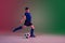 Teen male football or soccer player, boy on gradient background in neon light - motion, action, activity concept