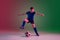 Teen male football or soccer player, boy on gradient background in neon light - motion, action, activity concept