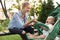 Teen nanny with cute baby in stroller playing