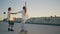 Teen pair riding skate board enjoying sunset stadium. Woman balancing skateboard