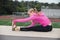 Teen in pink jacket activating muscles over field.