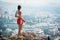 Teen in red shorts standing on rock overlooking Athens