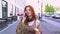 Teen redhead hipster girl talking on phone walking on city urban street.