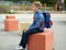Teen schoolboy with backpack sitting in the school yard