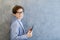 Teen schooler boy in eyeglasses holds tablet