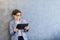 Teen schooler boy in eyeglasses holds tablet PC