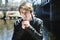 Teen sits outside close to a bridge Leather jacket.