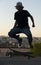 Teen Skateboarder doing jump trick in urban location