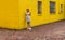 Teen standing next to bright yellow wall