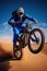 teen stunt dirt bike extreme sports. sandy dunes in the blue sky desert.