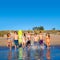 Teen surfers group running beach splashing