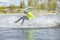 Teen Wakeboarder on wakeboard landed in water surrounded by splash. Wakeboarding is an extreme sport