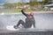 Teen Wakeboarder on wakeboard landed in water surrounded by splash. Wakeboarding is an extreme sport