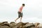 Teen walking barefoot on beach rocks