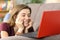 Teen watching media content on line in a red laptop