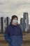 Teen wearing a medical mask against the background of a city against quarantine